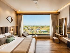 a hotel room with a large bed and a large window at Sterling Pushkar in Pushkar