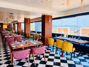 a restaurant with tables and chairs and windows at Sterling Pushkar in Pushkar