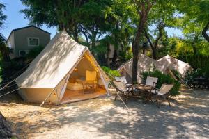 a tent with a table and chairs in a yard at Kampaoh Estepona in Estepona