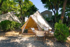 a tent with a bunch of chairs in front of it at Kampaoh Estepona in Estepona +28 photos