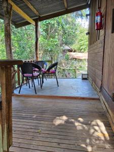 a patio with two chairs and a table on a porch at Big Hug Home in Ko Yao Noi