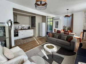 a living room with a couch and a kitchen at Maison 85 m2 deux chambres in Cazères