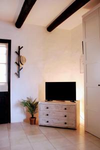 a living room with a television on a wooden dresser at Finca Rivari in Tinajo