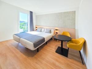 a bedroom with a bed and a table and a yellow chair at DWO San Sebastián in San Sebastián +24 photos