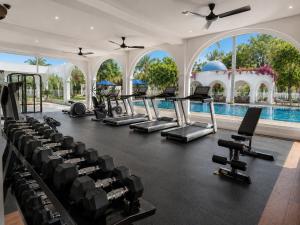 an indoor gym with cardio equipment and a swimming pool at Signature 2BR - Deluxe - Santorini - Negombo in Negombo