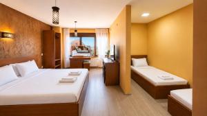 a hotel room with two beds and a television at Makadam Hotel in Prizren