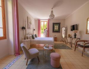 a bedroom with a bed and a chair and a table at Hôtel La Villa Sainte Valérie Adults Only in Juan-les-Pins