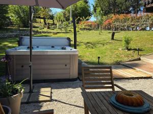 a hot tub with a cake on a table with an umbrella at Country home Lagom in Zagorska Sela