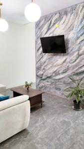 a living room with a white couch and a stone wall at Ap Blessedplace Rîșcani-New Bldg in Chişinău