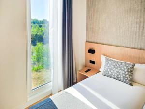 a bedroom with a bed next to a window at DWO San Sebastián in San Sebastián