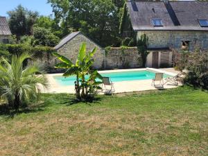 a swimming pool in the backyard of a house at Zélie Gîte in Ambillou-Château