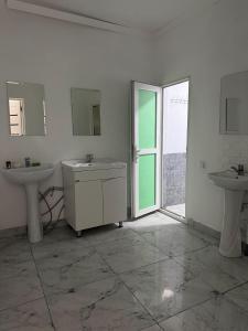 a bathroom with two sinks and two mirrors at 名宿 395 Hostel in Bishkek