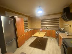 a kitchen with a small table and a refrigerator at Bissan Condimenium in Amman