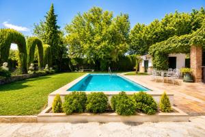 a swimming pool in the middle of a yard at Molino de Búlar - 1920 Olive Oil Mill Heritage in Piñar