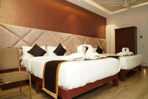 two swans on two beds in a hotel room at Hotel G Grand Inn in Thanjāvūr