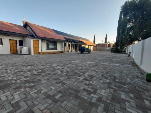 a brick driveway in front of a building at The Lantern Porch Guesthouse in Vryburg