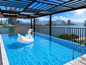 a swimming pool with a swan in the water at Ngoc Thuong Hotel & Apartment- Han River View in Danang