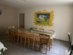 a dining room with a long table and chairs at Meublé lilas in Réaumur