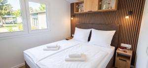 ein Schlafzimmer mit einem Bett, auf dem zwei weiße Handtücher liegen in der Unterkunft Tinyhouse SeeZeit in Lohmen + 19 Fotos