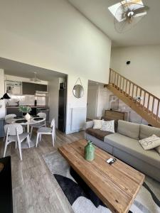 a living room with a couch and a table at Le Vigne - Terrasse privée in Aytré