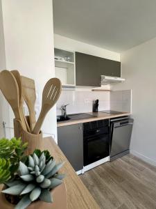 a kitchen with a table and a stove top oven at Le Vigne - Terrasse privée in Aytré +8 photos