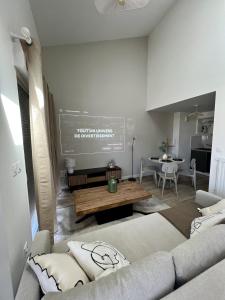 a living room with a couch and a table at Le Vigne - Terrasse privée in Aytré