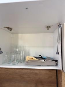 a white counter with glasses and books on it at Little Studio Prespa Best Location in Varna City