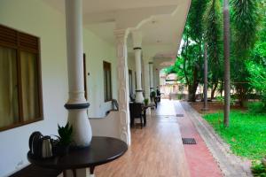 a hallway of a building with tables and palm trees at Trinco Eddi Resort in Trincomalee