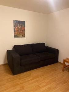 a black couch in a living room with a painting at Cameretta Pineta Carì in Molare
