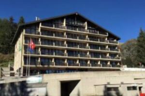a large building with a flag in front of it at Cameretta Pineta Carì in Molare