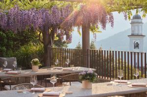 a table with wine glasses and purple wisterias at Relais Castello di Morcote in Morcote