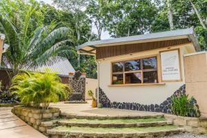 a small building with a window and stairs at Villas Roca del Caribe in Puerto Viejo