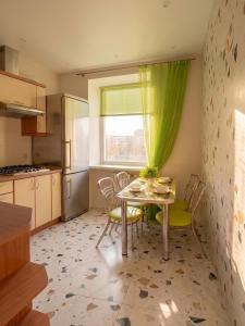 a kitchen with a table and chairs and a window at Luxury 3 Rooms Apartments in Center by Green House in Poltava