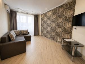 a living room with a couch and a piano at Luxury 3 Rooms Apartments in Center by Green House in Poltava