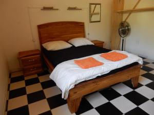 ein Schlafzimmer mit einem Bett mit zwei orangenen Handtüchern darauf in der Unterkunft Contany Counda in Abémé