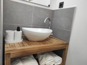 a bathroom with a white bowl sink on a wooden shelf at Alte Schule Gästehaus - Klassenzimmer Loft in Bitburg +19 photos