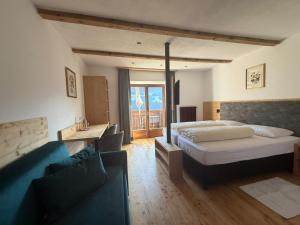 a hotel room with a bed and a couch at Hotel Alpenland in Moso +45 photos