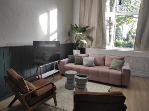a living room with a pink couch and a tv at Alte Schule Gästehaus - Klassenzimmer Loft in Bitburg