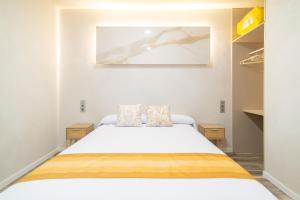 a bedroom with a white bed in a room at Apartamentos El Real in Mota del Cuervo