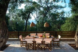 a wooden table with chairs and a tableasteryasteryasteryasteryasteryasteryasteryastery at Villa Praxithea in Lákka