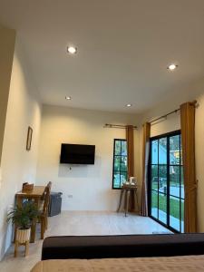 a living room with a flat screen tv on the wall at Langbaan cafe and homestay in Ban Mai