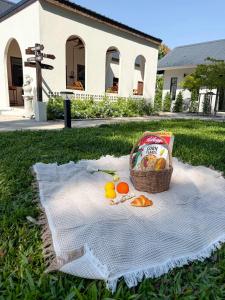 a basket of fruit sitting on a blanket on the grass at Langbaan cafe and homestay in Ban Mai