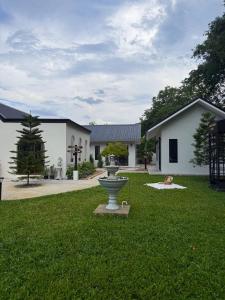 a building with a fountain in the middle of a yard at Langbaan cafe and homestay in Ban Mai