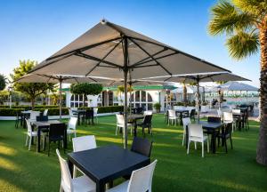 a group of tables and chairs under an umbrella at Hotel Alb's in Alba Adriatica