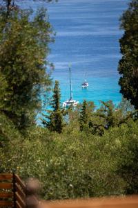 two boats in the ocean with trees and water at Villa Praxithea in Lákka