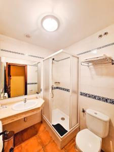 a bathroom with a shower and a toilet and a sink at Hotel-Albergue Puente Fitero in Itero de la Vega