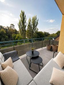 a patio with a couch and a table on a balcony at Veľký rodinný apartmán s výhľadom na zeleň a hory v centre Piešťan s parkovaním in Piešťany