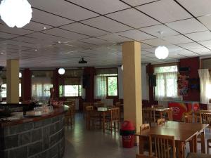 a dining room with tables and chairs and lights at El Chate Tiendas in Sarvisé
