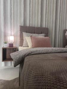 a bedroom with a large bed and a side table at Apartman Aleksandra 2 in Bečej