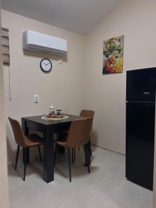 a dining room with a black table and chairs at Apartman Aleksandra 2 in Bečej